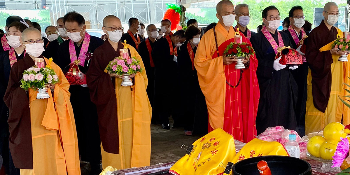 靈鷲山常住法師、貴賓、工程團隊數十人，雙手合十稱誦佛號，歡喜合影。