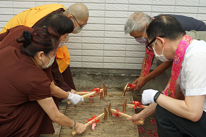 靈鷲山常住法師、貴賓、工程團隊數十人，雙手合十稱誦佛號，歡喜合影。